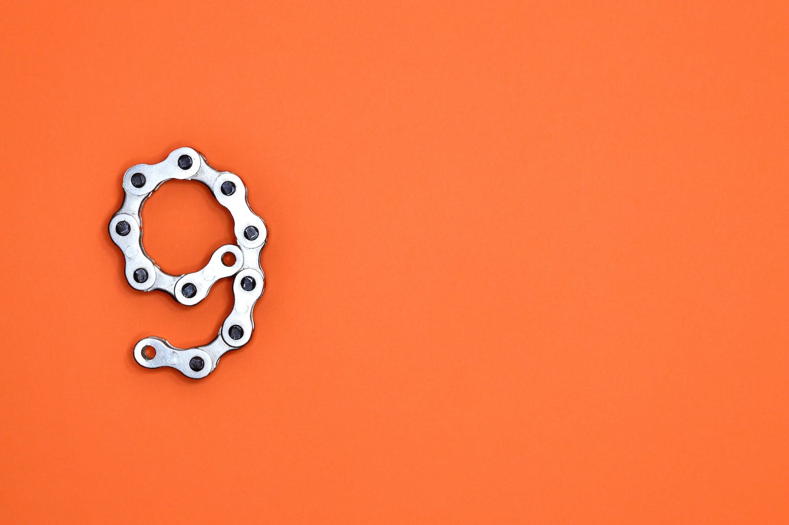 Gray Bicycle Chain on Orange Surface